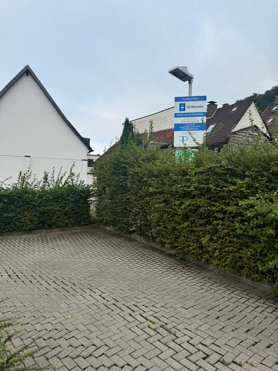Außenanlage mit Hecke an einem Kundenparkplatz vor der Pflege durch EKO FORST in Bad Lauterberg im Harz